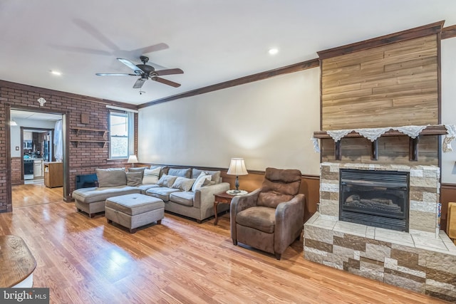 2609 E Monmouth St, Philadelphia, PA 19134 - living room featuring wood finished floors, ceiling fan, a fireplace, ornamental molding, and brick wall