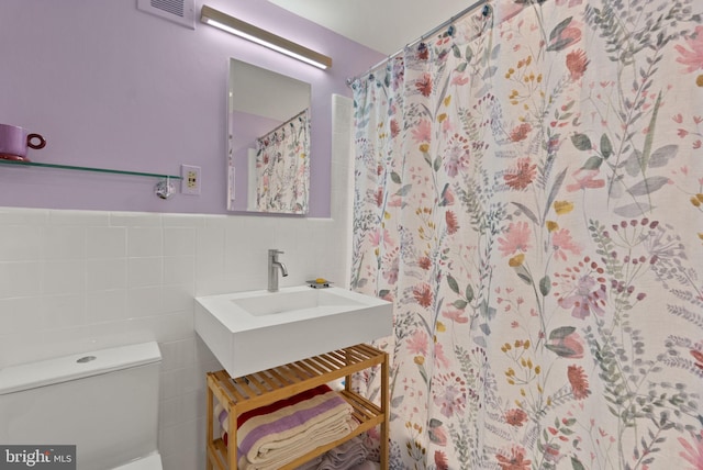 116 Cameron Mews, Alexandria, VA 22314 - bathroom featuring vanity, tile walls, toilet, a shower with shower curtain, and wainscoting