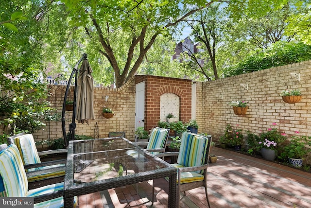 116 Cameron Mews, Alexandria, VA 22314 - fenced backyard with a wooden deck and outdoor dining space