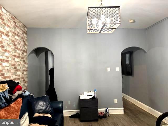 744 Cherry St, Camden, NJ 08103 - living area featuring arched walkways, wood finished floors, and baseboards