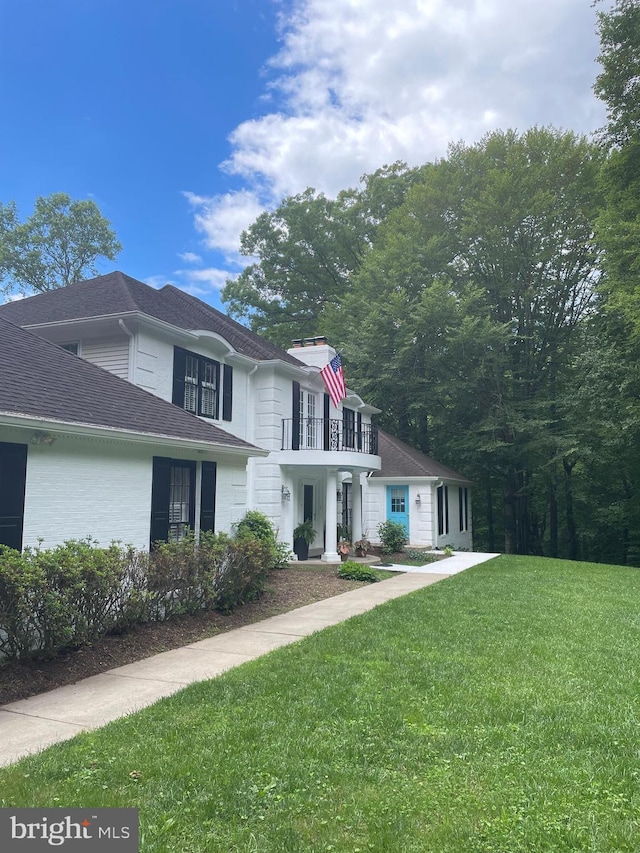 10200 Souza Ln, Manassas, VA 20111 - view of front of house featuring a balcony, a front lawn, a chimney, and a shingled roof