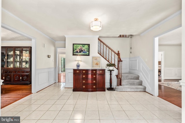 10200 Souza Ln, Manassas, VA 20111 - foyer featuring stairway, light tile patterned floors, a wainscoted wall, ornamental molding, and a decorative wall