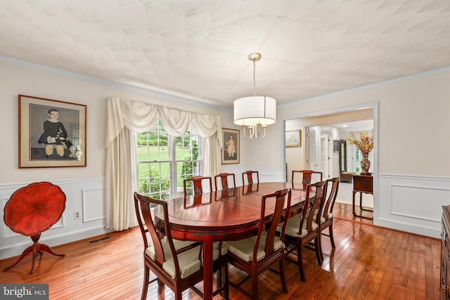 10200 Souza Ln, Manassas, VA 20111 - dining room with wainscoting, hardwood / wood-style flooring, a chandelier, a decorative wall, and ornamental molding