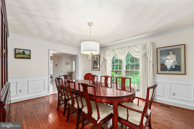 10200 Souza Ln, Manassas, VA 20111 - dining area with wood-type flooring, wainscoting, crown molding, and a decorative wall