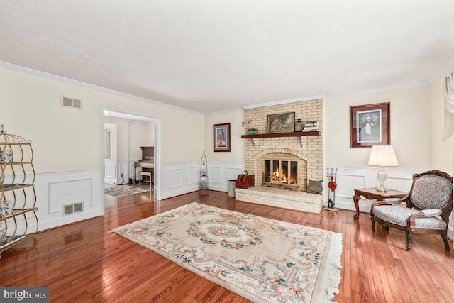 10200 Souza Ln, Manassas, VA 20111 - living room with ornamental molding, a brick fireplace, hardwood / wood-style floors, a wainscoted wall, and a decorative wall