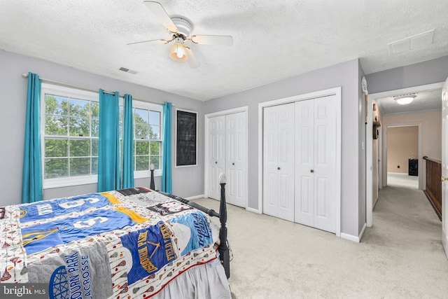 10200 Souza Ln, Manassas, VA 20111 - bedroom with a textured ceiling, light carpet, multiple closets, baseboards, and a ceiling fan