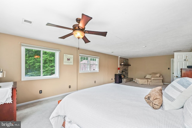 10200 Souza Ln, Manassas, VA 20111 - bedroom featuring light carpet, baseboards, a ceiling fan, and a fireplace