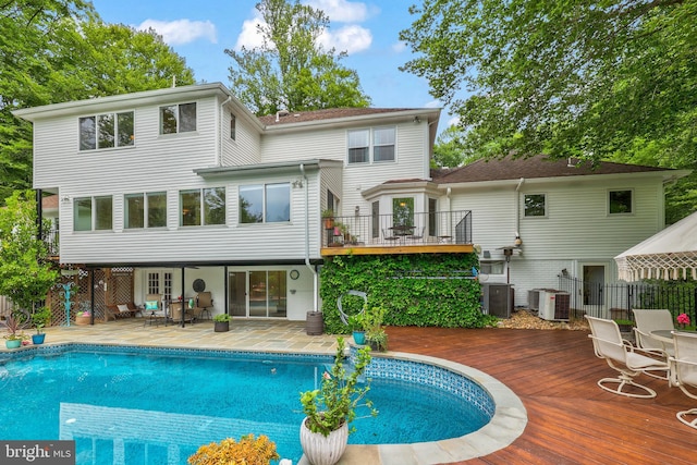 10200 Souza Ln, Manassas, VA 20111 - back of property with an outdoor pool, a deck, central AC unit, and a patio area