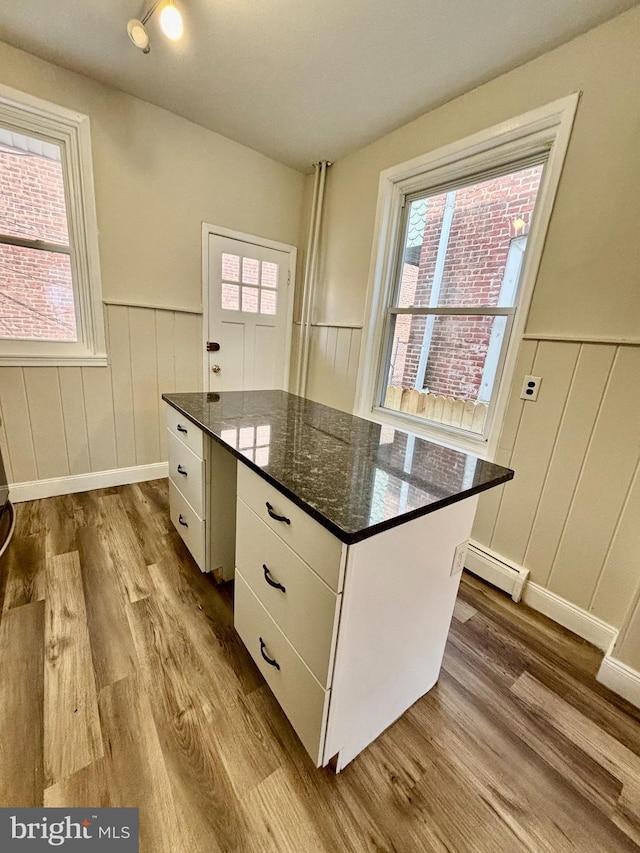 805 W Bristol St, Philadelphia, PA 19140 - kitchen featuring baseboard heating, dark wood-style floors, a wainscoted wall, white cabinets, and a center island