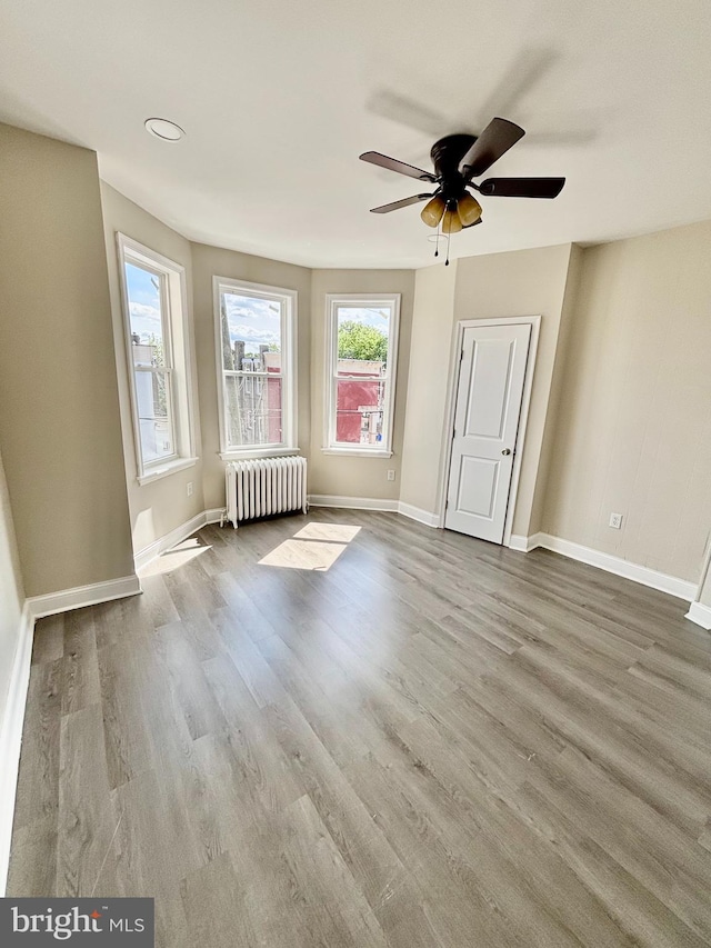 805 W Bristol St, Philadelphia, PA 19140 - unfurnished living room featuring radiator heating unit, ceiling fan, wood finished floors, and baseboards