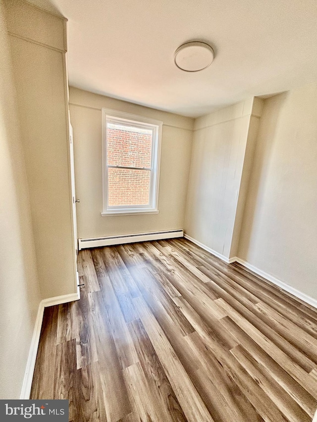 805 W Bristol St, Philadelphia, PA 19140 - empty room with a baseboard radiator, wood finished floors, and baseboards
