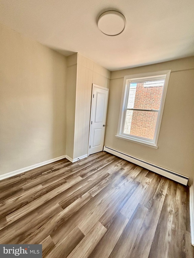 805 W Bristol St, Philadelphia, PA 19140 - spare room featuring a baseboard radiator, wood finished floors, and baseboards
