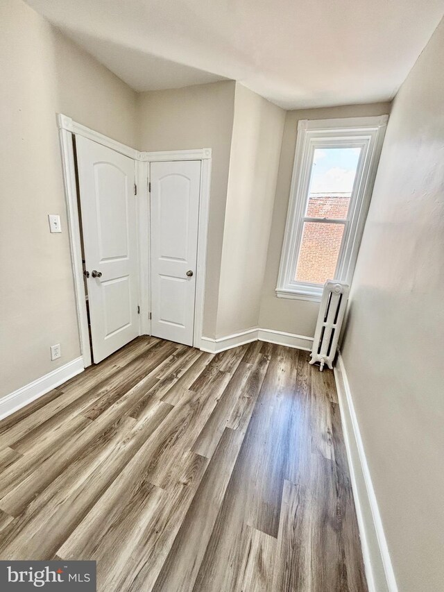 805 W Bristol St, Philadelphia, PA 19140 - unfurnished bedroom with radiator, wood finished floors, and baseboards