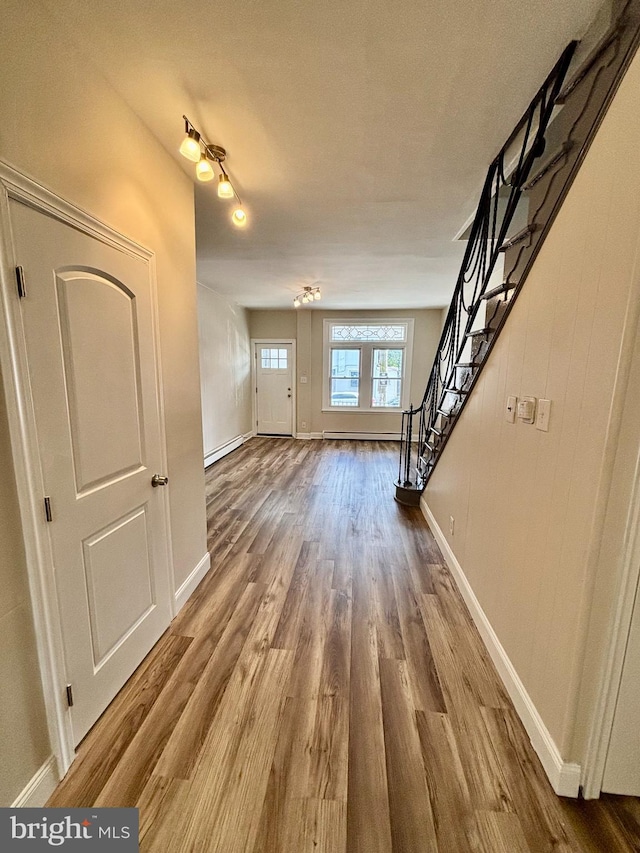 805 W Bristol St, Philadelphia, PA 19140 - unfurnished living room with wood finished floors, stairs, baseboards, and a baseboard heating unit
