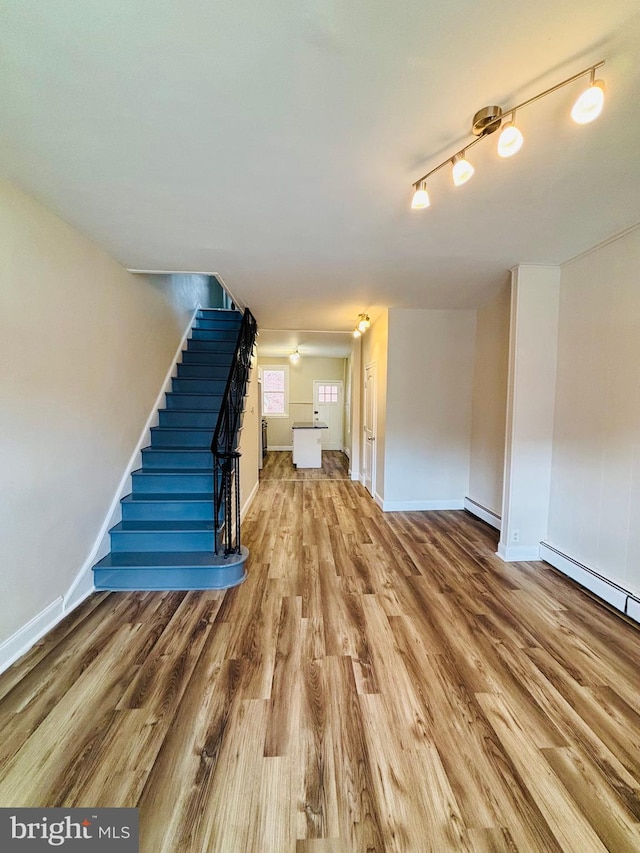 805 W Bristol St, Philadelphia, PA 19140 - unfurnished living room with wood finished floors, baseboard heating, stairs, and baseboards