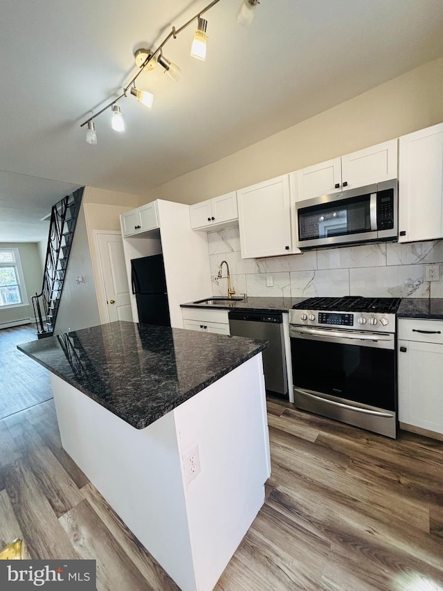 805 W Bristol St, Philadelphia, PA 19140 - kitchen featuring appliances with stainless steel finishes, a sink, white cabinetry, and decorative backsplash