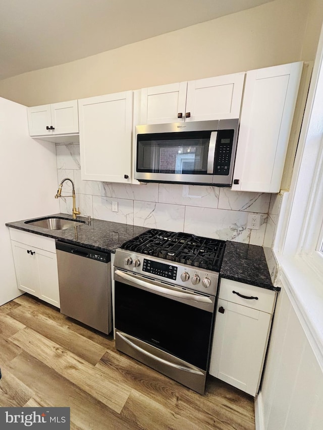 805 W Bristol St, Philadelphia, PA 19140 - kitchen featuring appliances with stainless steel finishes, a sink, white cabinetry, and tasteful backsplash