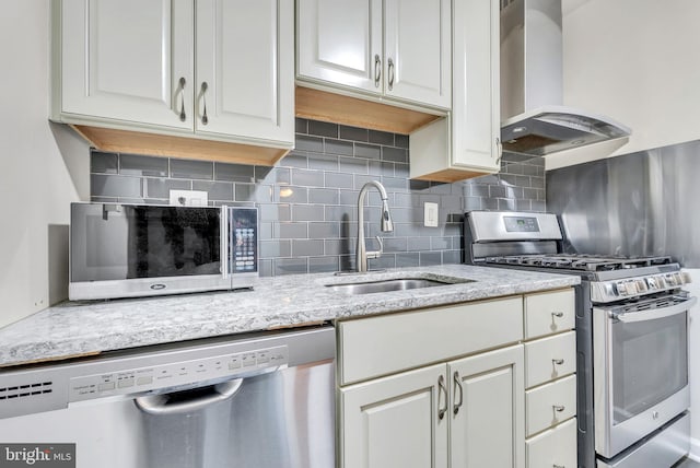 4201 Cathedral Ave NW Unit 918W, Washington, DC 20016 - kitchen with appliances with stainless steel finishes, wall chimney range hood, a sink, tasteful backsplash, and white cabinets