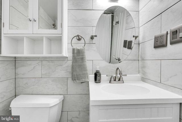 4201 Cathedral Ave NW Unit 918W, Washington, DC 20016 - bathroom with tile walls, toilet, vanity, and tasteful backsplash