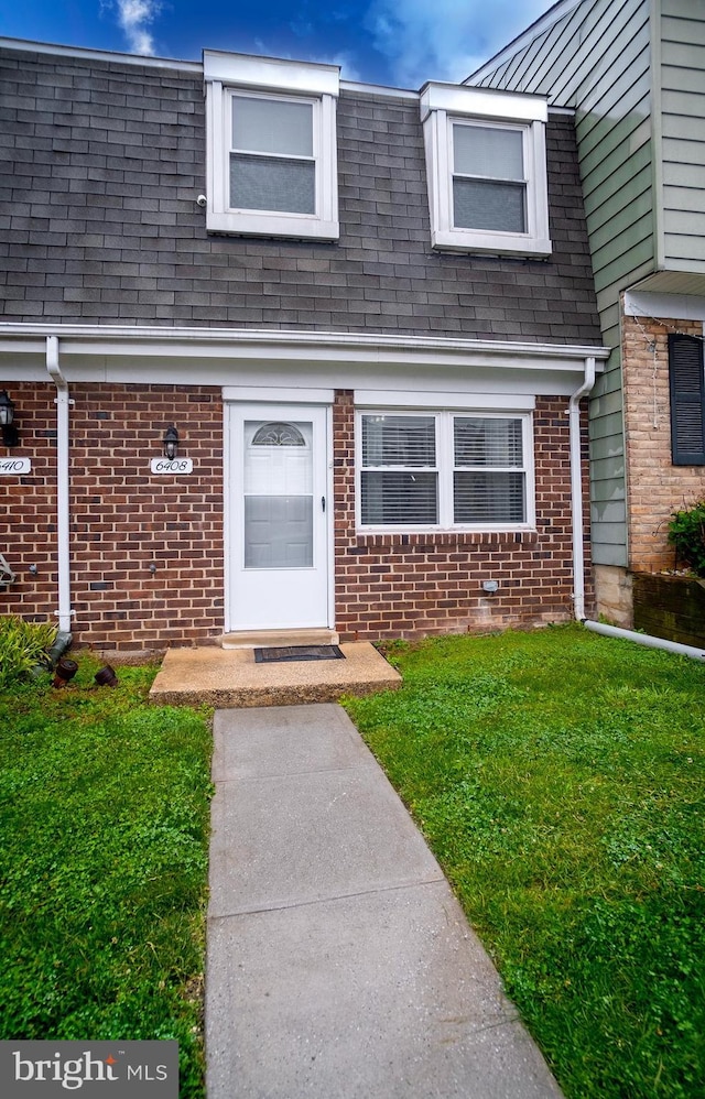 6408 Jefferson Pl, Glen Burnie, MD 21061 - view of front of house with a shingled roof, a front lawn, and brick siding