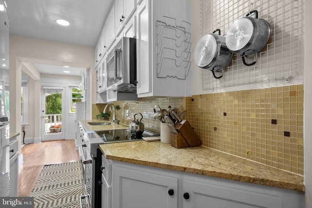 1937 38th St NW, Washington, DC 20007 - kitchen with appliances with stainless steel finishes, white cabinets, light wood finished floors, light stone counters, and recessed lighting
