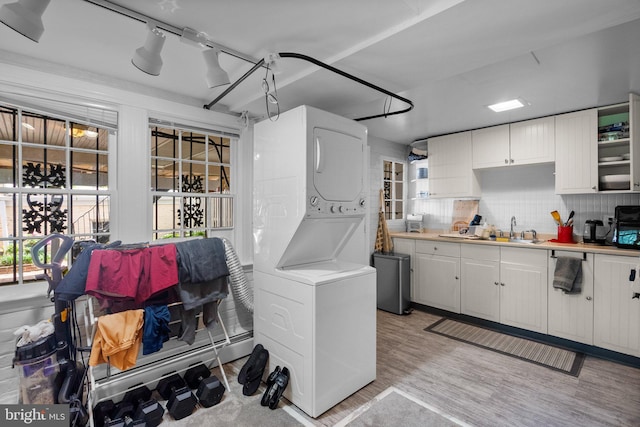 1937 38th St NW, Washington, DC 20007 - kitchen featuring stacked washer / dryer, white cabinetry, light countertops, and healthy amount of natural light