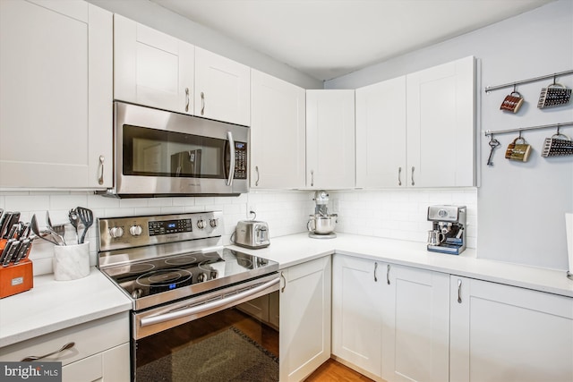 1312 Massachusetts Ave NW Unit 604, Washington, DC 20005 - kitchen with appliances with stainless steel finishes, light countertops, decorative backsplash, and white cabinetry