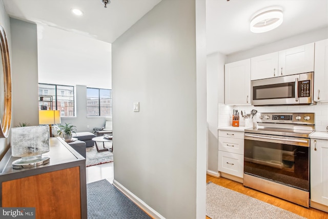 1312 Massachusetts Ave NW Unit 604, Washington, DC 20005 - kitchen with appliances with stainless steel finishes, white cabinetry, tasteful backsplash, light wood-style flooring, and recessed lighting