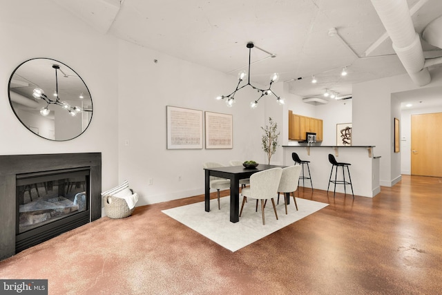 1700 Kalorama Rd NW Unit 206, Washington, DC 20009 - dining space featuring a chandelier, finished concrete floors, baseboards, and a glass covered fireplace