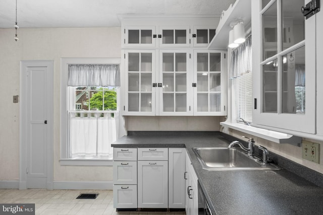 15 E Grant St, Woodstown, NJ 08098 - kitchen with a sink, dark countertops, glass insert cabinets, and baseboards