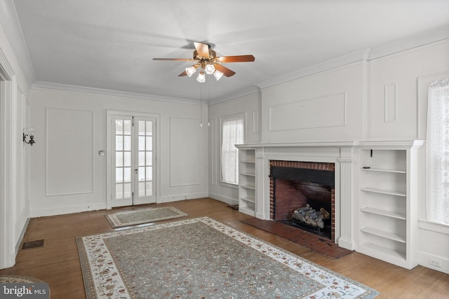 15 E Grant St, Woodstown, NJ 08098 - unfurnished living room with a ceiling fan, wood finished floors, a brick fireplace, ornamental molding, and a decorative wall