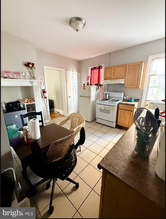 133 Suydam St, New Brunswick, NJ 08901 - kitchen with white appliances, under cabinet range hood, light brown cabinetry, and light tile patterned flooring