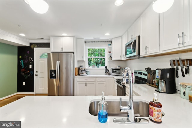 5310 B St SE, Washington, DC 20019 - kitchen featuring appliances with stainless steel finishes, white cabinetry, light countertops, recessed lighting, and ornamental molding