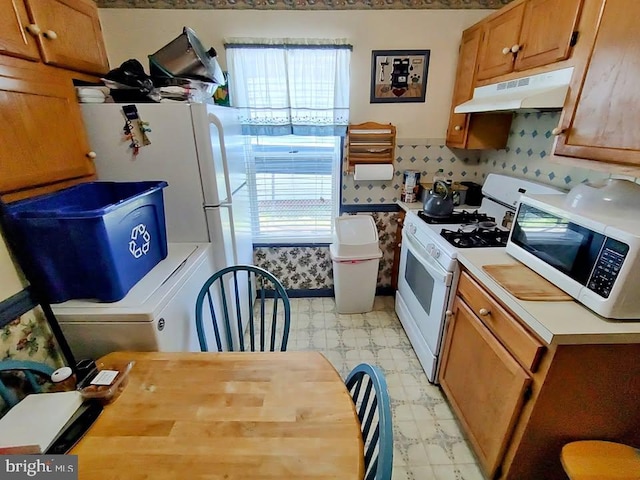 427 Camper St, Cambridge, MD 21613 - kitchen with under cabinet range hood, light flooring, white appliances, light countertops, and brown cabinets