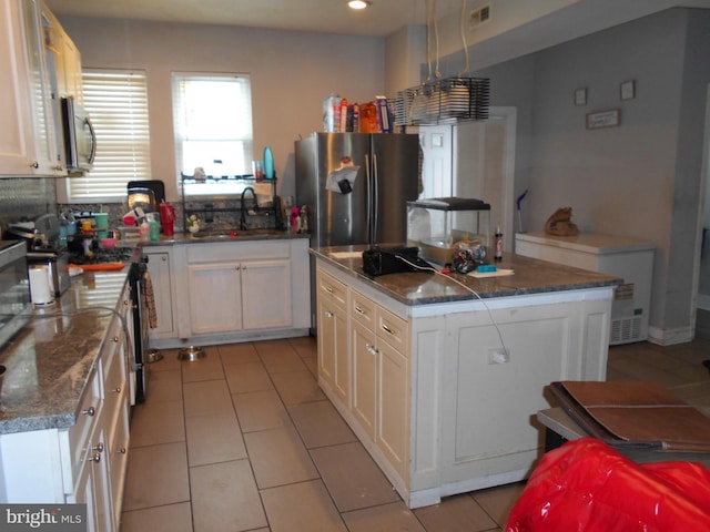 4708 Frederick Ave, Baltimore, MD 21229 - kitchen featuring a sink, stainless steel appliances, light tile patterned floors, white cabinetry, and a kitchen island