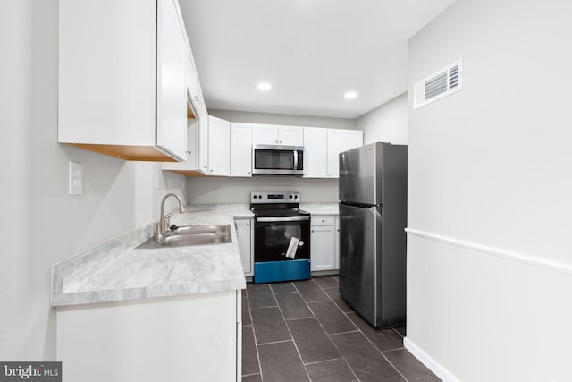 231 Ivanhoe Ct, Fredericksburg, VA 22401 - kitchen with stainless steel appliances, a sink, white cabinetry, light countertops, and recessed lighting