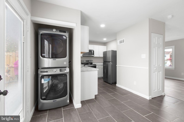 231 Ivanhoe Ct, Fredericksburg, VA 22401 - laundry room with estacked washer and dryer, recessed lighting, baseboards, and dark tile patterned floors