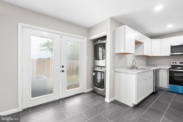 231 Ivanhoe Ct, Fredericksburg, VA 22401 - kitchen featuring stainless steel appliances, a sink, stacked washer / drying machine, light countertops, and white cabinetry