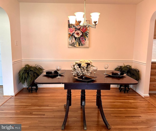 5420 Eastbourne Dr, Springfield, VA 22151 - dining area with arched walkways, wood finished floors, a chandelier, and baseboards