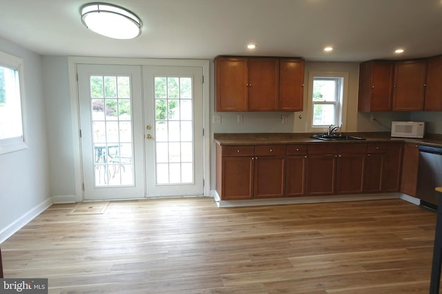 413 Dominion Rd, Chester, MD 21619 - kitchen with dishwasher, white microwave, dark countertops, a sink, and light wood-style flooring