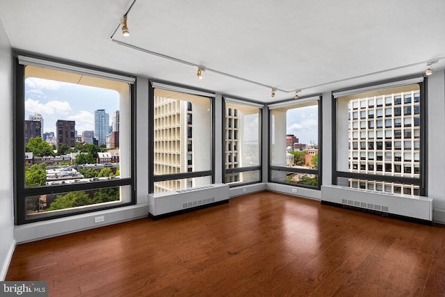 220 Locust St Unit 7As, Philadelphia, PA 19106 - unfurnished room with a skyline view, rail lighting, plenty of natural light, and wood finished floors