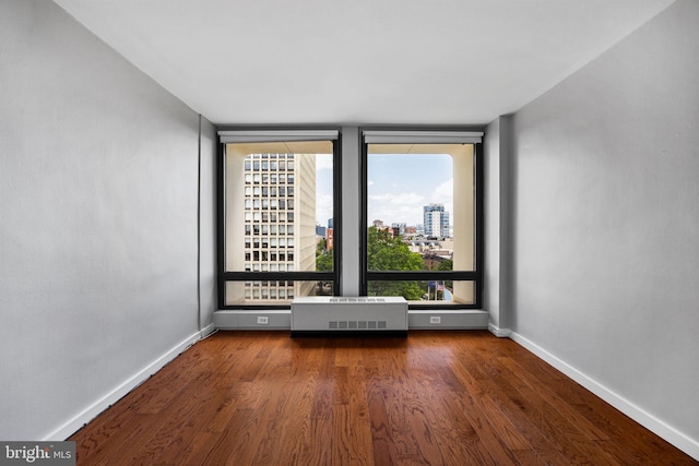 220 Locust St Unit 7As, Philadelphia, PA 19106 - spare room featuring radiator, wood finished floors, and a city view