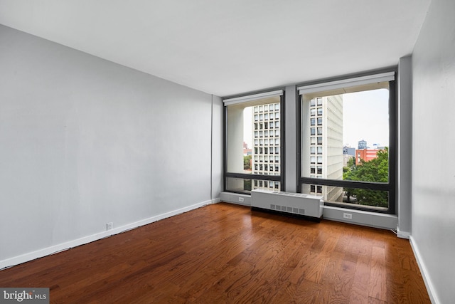220 Locust St Unit 7As, Philadelphia, PA 19106 - unfurnished room featuring wood finished floors, radiator heating unit, and a view of city