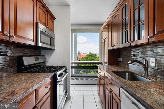 220 Locust St Unit 7As, Philadelphia, PA 19106 - kitchen with appliances with stainless steel finishes, dark stone countertops, backsplash, glass insert cabinets, and light tile patterned floors