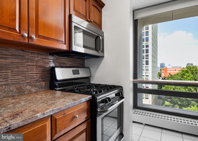 220 Locust St Unit 7As, Philadelphia, PA 19106 - kitchen featuring appliances with stainless steel finishes, tasteful backsplash, light tile patterned flooring, and brown cabinets