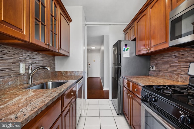220 Locust St Unit 7As, Philadelphia, PA 19106 - kitchen with appliances with stainless steel finishes, light tile patterned flooring, light stone countertops, glass insert cabinets, and brown cabinets