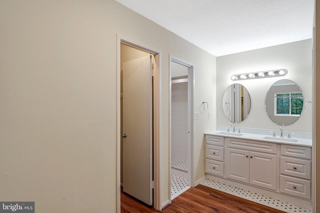 8370 Greensboro Dr Unit 508, Mclean, VA 22102 - bathroom featuring wood finished floors, double vanity, tiled shower, and baseboards