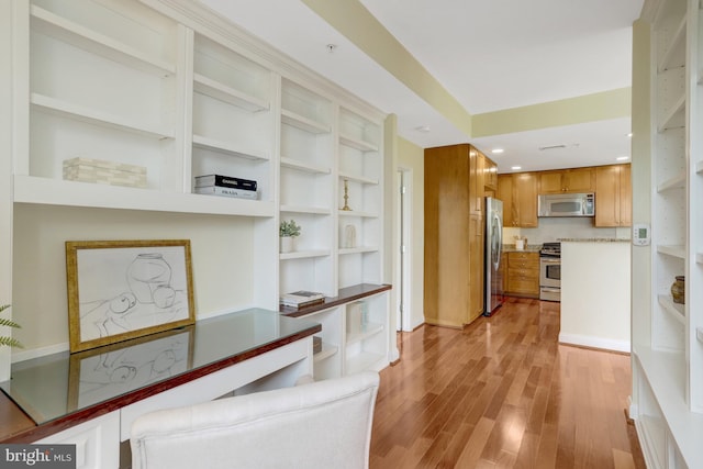 513 W Broad St Unit 602, Falls Church, VA 22046 - kitchen with stainless steel appliances, brown cabinetry, open shelves, and light wood-type flooring
