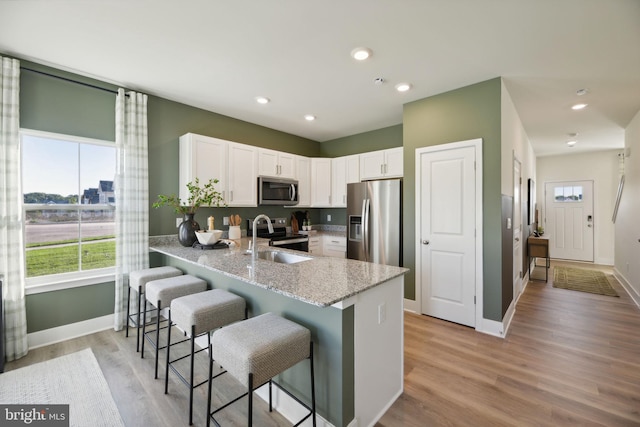 112 Pomo Ln, Winchester, VA 22602 - kitchen with stainless steel appliances, baseboards, a peninsula, light stone countertops, and recessed lighting