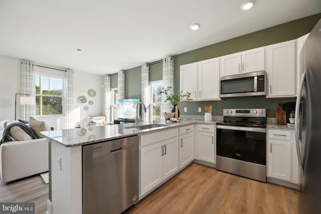 112 Pomo Ln, Winchester, VA 22602 - kitchen with stainless steel appliances, a sink, a peninsula, white cabinetry, and recessed lighting